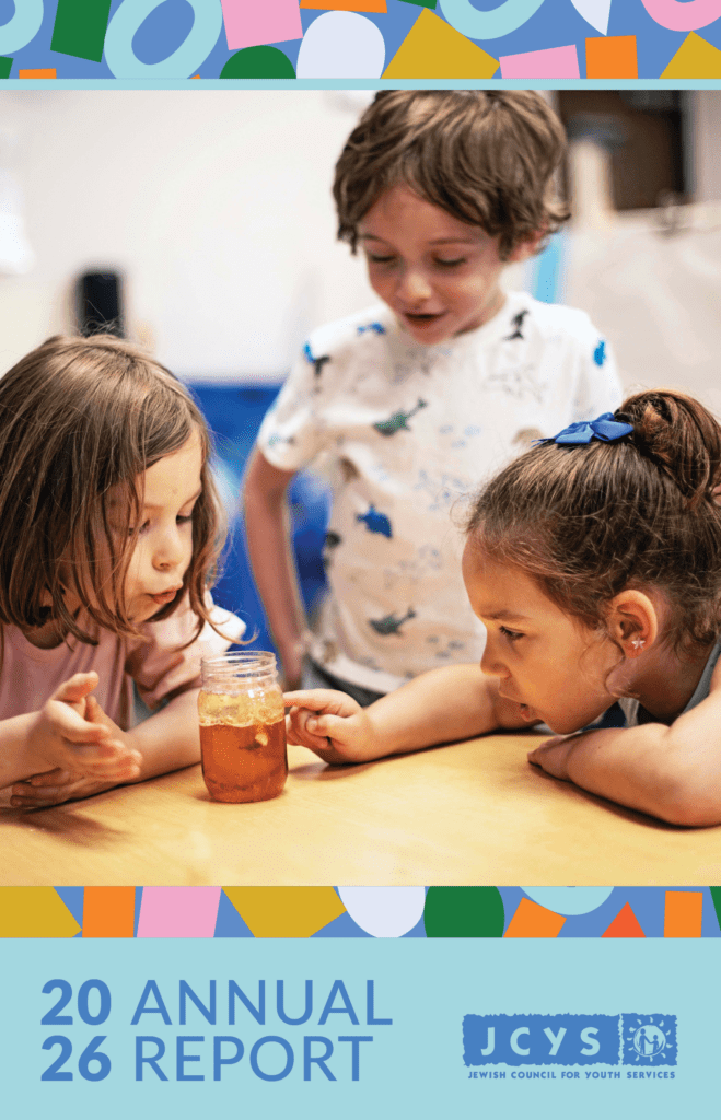A young girl sits at a table, stacking colorful blocks. The image is the cover of a 2025 annual report for JCYS, with the title and organization logo displayed at the top and bottom of the page.