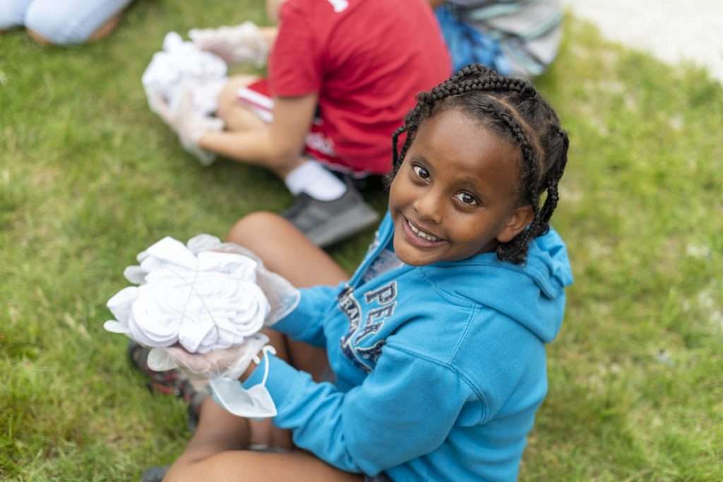 Child tie-dying a camp shirt